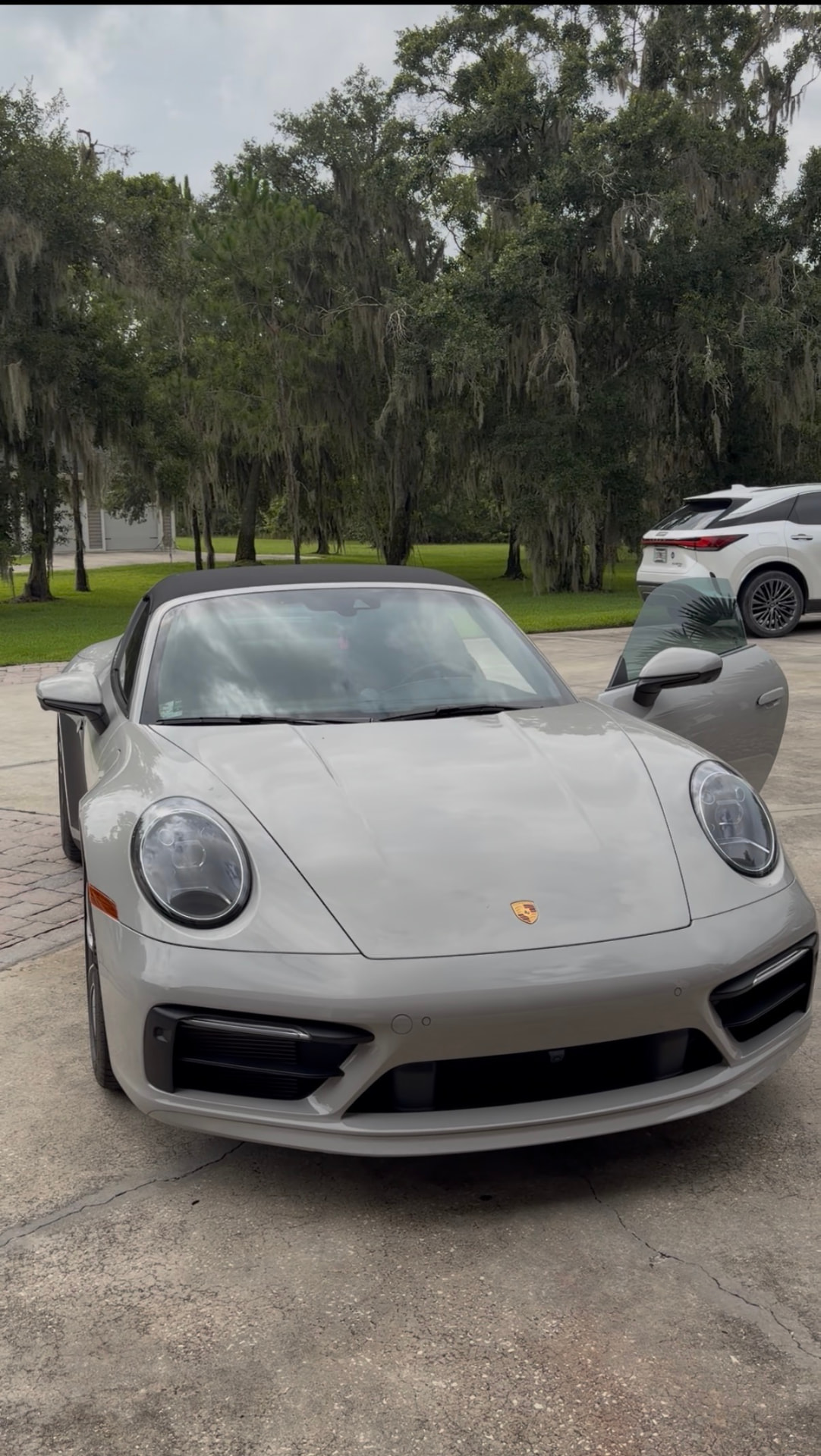Silver Porsche 911 convertible detailed in a driveway